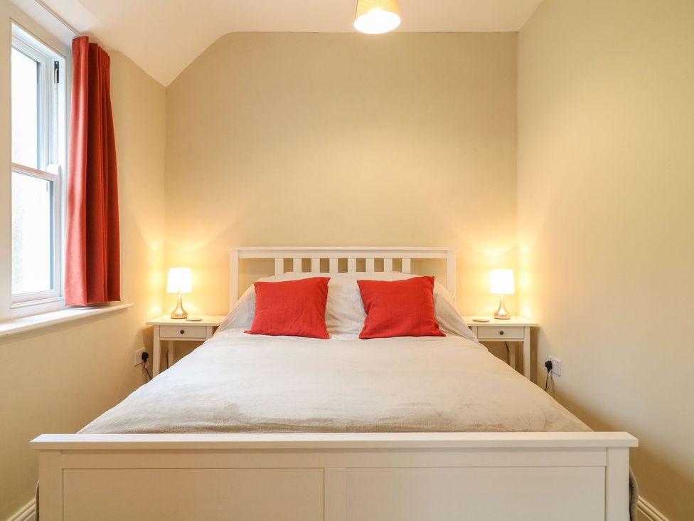 A bedroom with a bed, nightstands and lamps at School House in Ivybridge