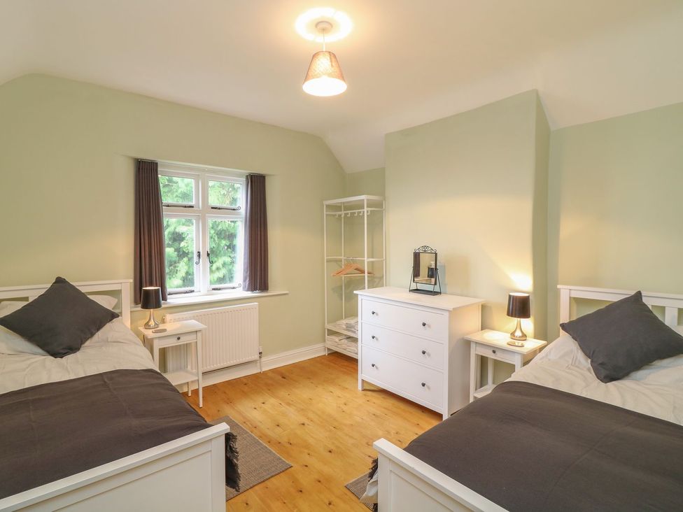 A bedroom with two beds and a dresser at School House in Ivybridge
