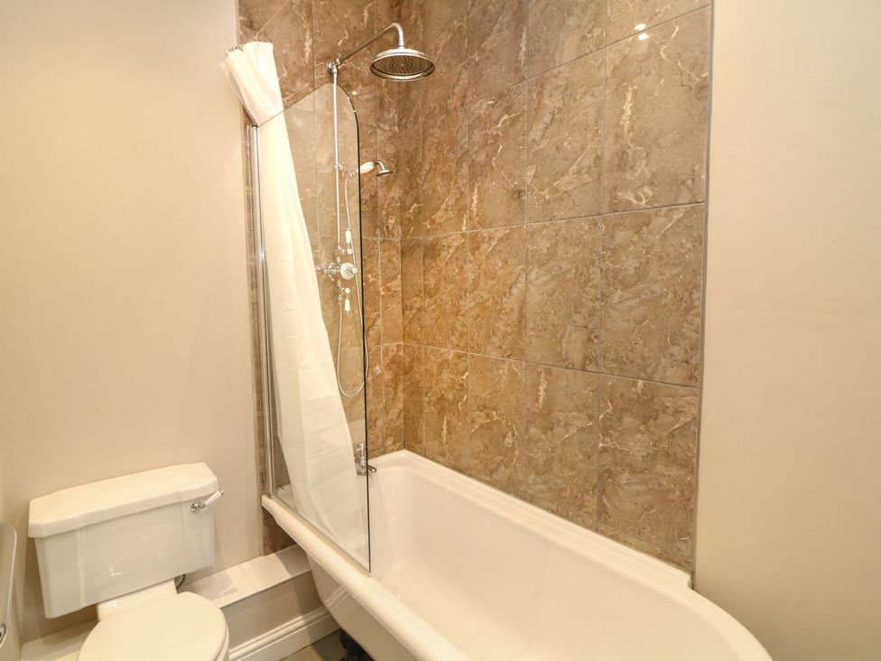 A bathroom with a bathtub and a toilet at School House in Ivybridge