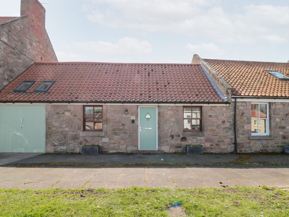 A house with a green door and windows at Cygnet Cottage in Berwick-upon-Tweed