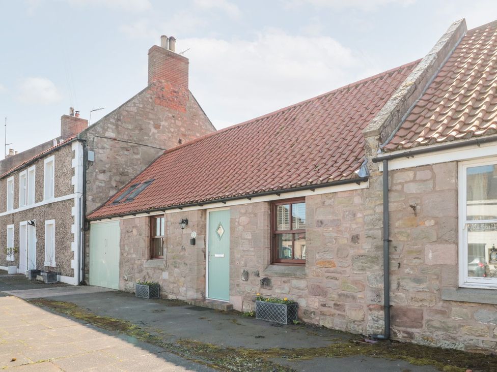 A stone cottage with a door and window in Berwick-upon-Tweed