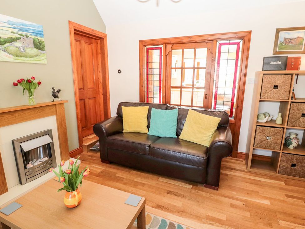 A living room with a sofa and a fireplace at Cygnet Cottage Berwick-upon-Tweed