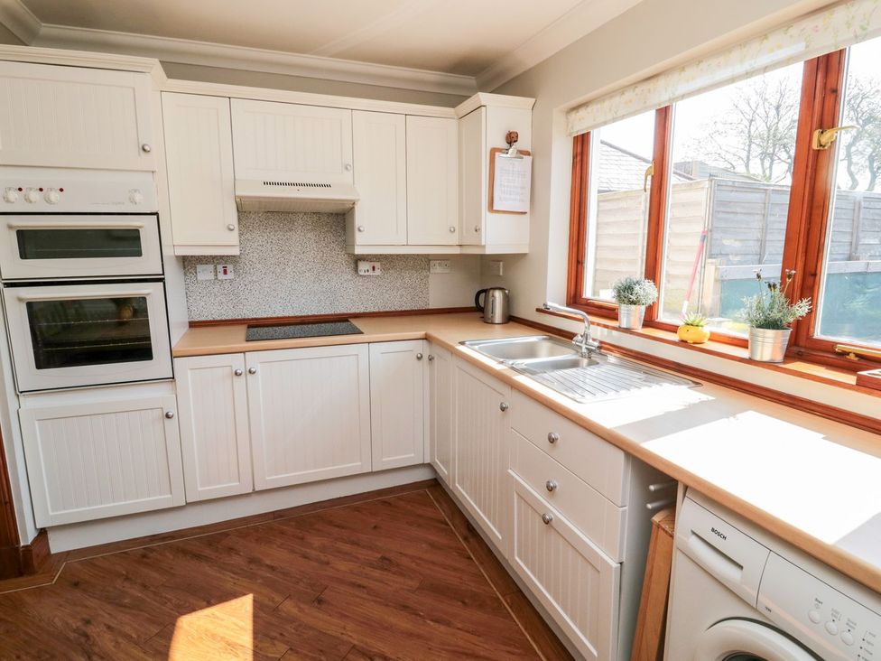 A kitchen with cabinets and appliances at Cygnet Cottage in Berwick-upon-Tweed