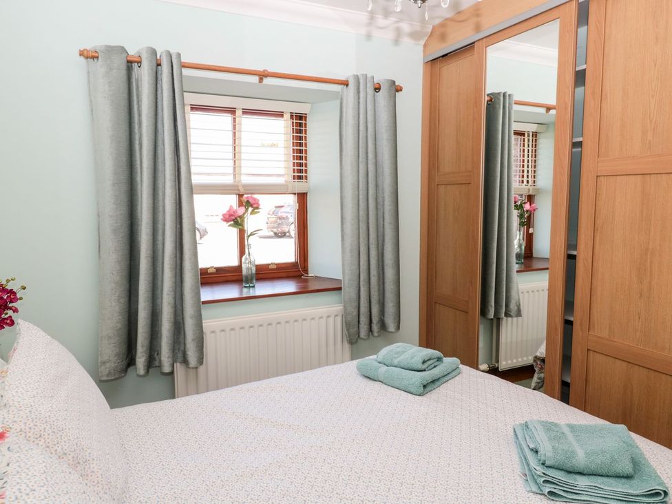 A bedroom with a bed and a window at Cygnet Cottage in Berwick-upon-Tweed