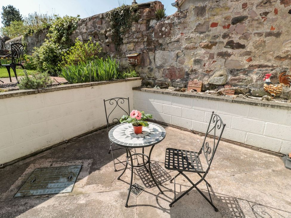 A seating area with a table and chairs in the garden at Cygnet Cottage Berwick-upon-Tweed