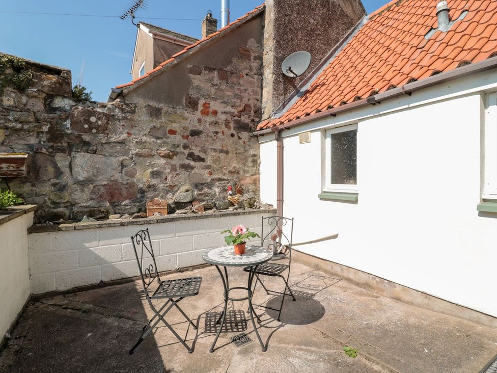 An outdoor seating area with a table and chairs at Cygnet Cottage Berwick-upon-Tweed