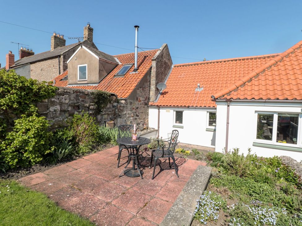 A garden with a table and chairs at Cygnet Cottage in Berwick-upon-Tweed