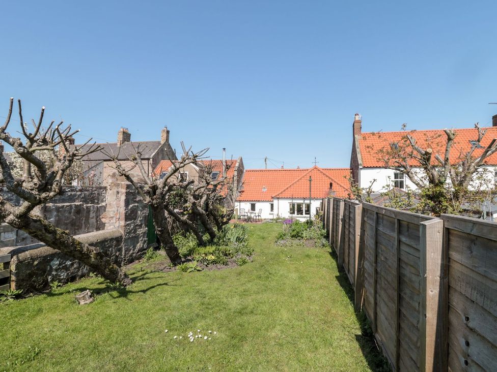 A garden with trees and grass at Cygnet Cottage Berwick-upon-Tweed