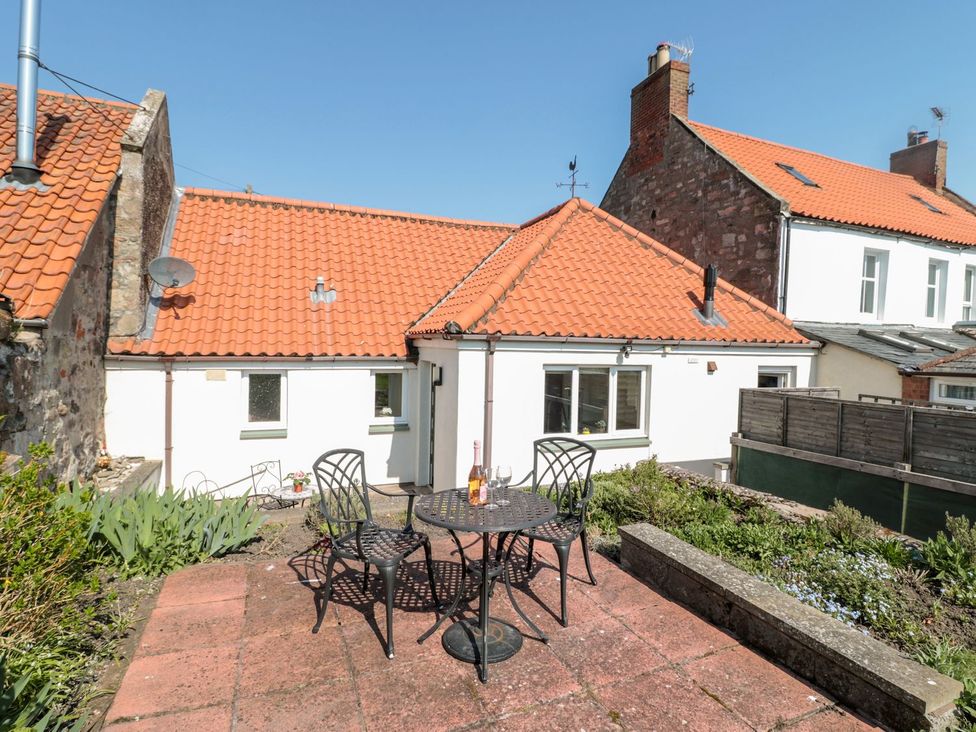 A garden with a table and chairs at Cygnet Cottage in Berwick-upon-Tweed