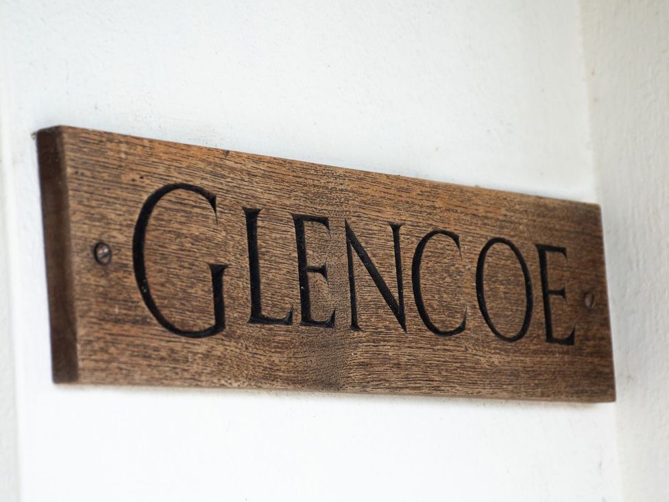 A wooden sign displaying the name Glencoe at Glencoe Cottage in Broadway