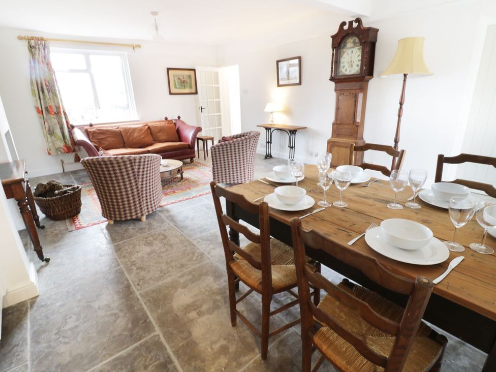 A dining room with a table and seating area at Glencoe Cottage in Broadway