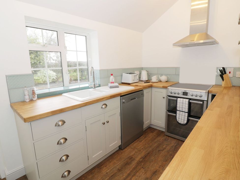 A kitchen with a sink, dishwasher, oven, and toaster at Glencoe Cottage in Broadway