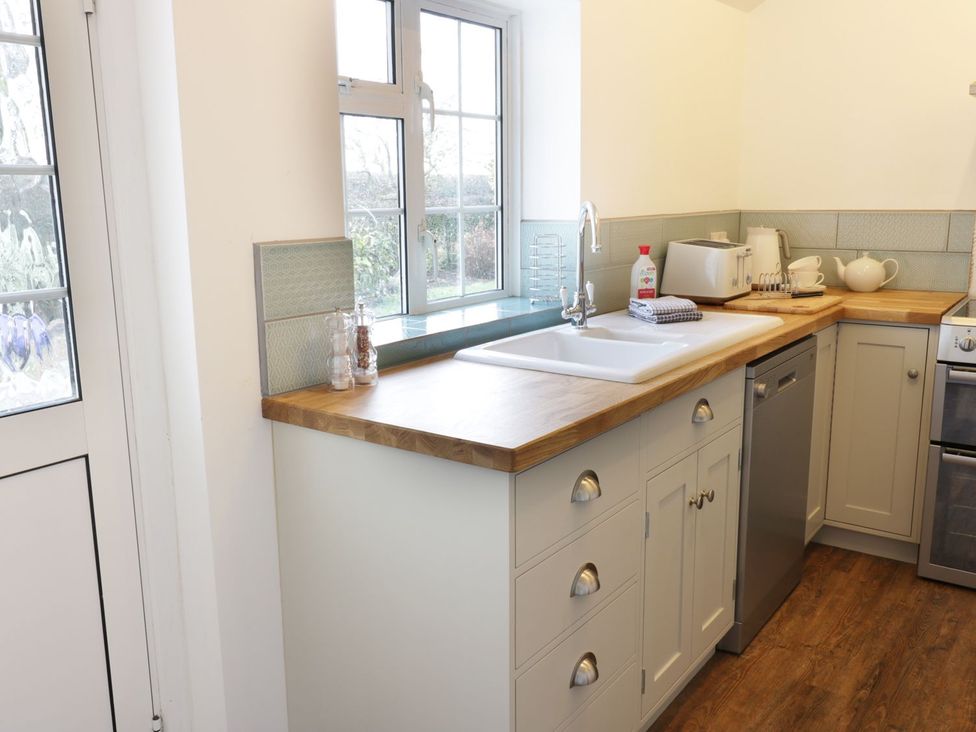 A kitchen with a sink and various kitchen appliances at Glencoe Cottage in Broadway
