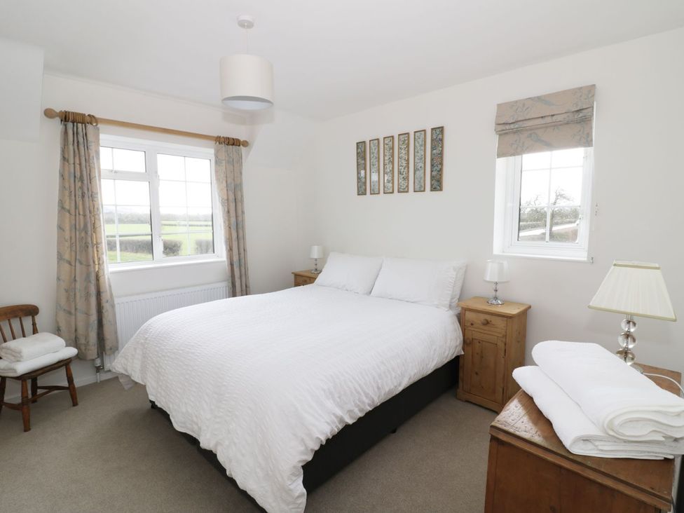 A bedroom with a bed and nightstand at Glencoe Cottage in Broadway