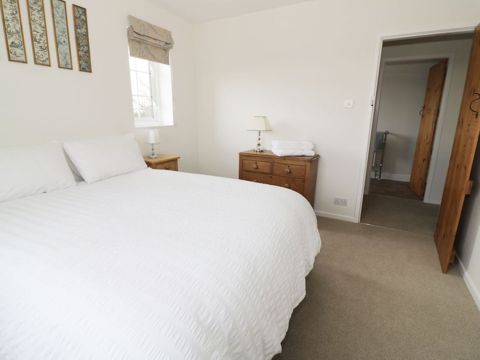 A bedroom with a bed and nightstand at Glencoe Cottage in Broadway