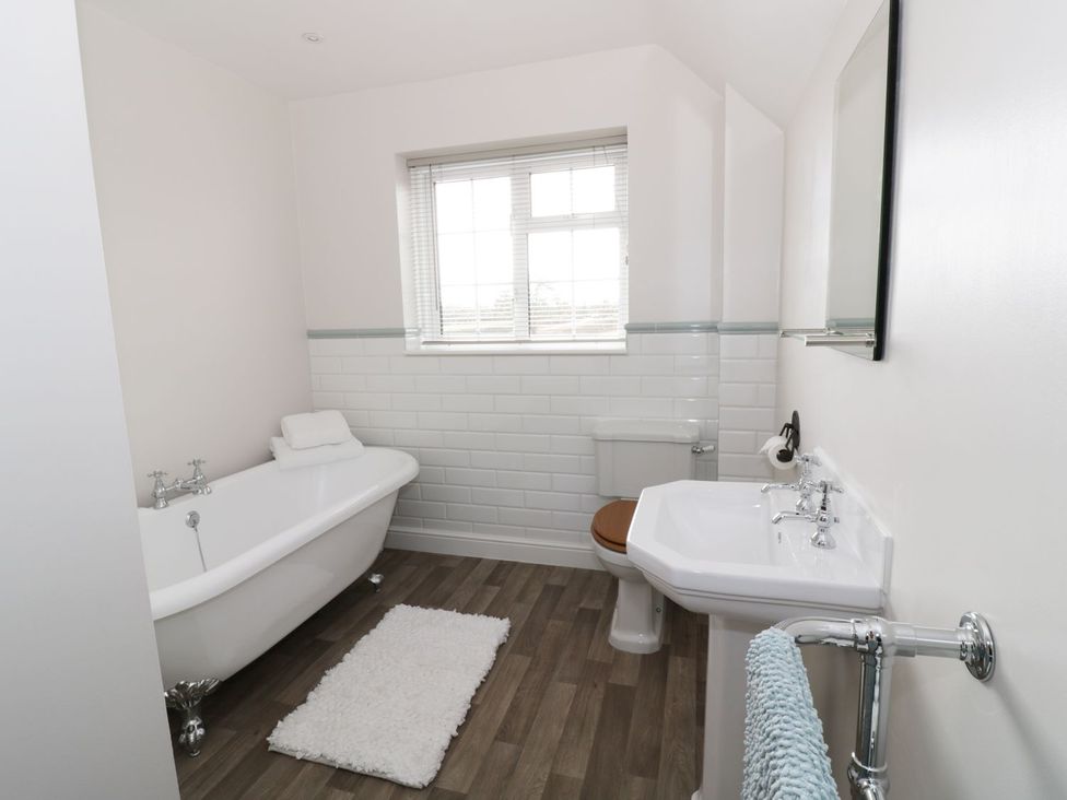 A bathroom with a bathtub and washbasin at Glencoe Cottage in Broadway