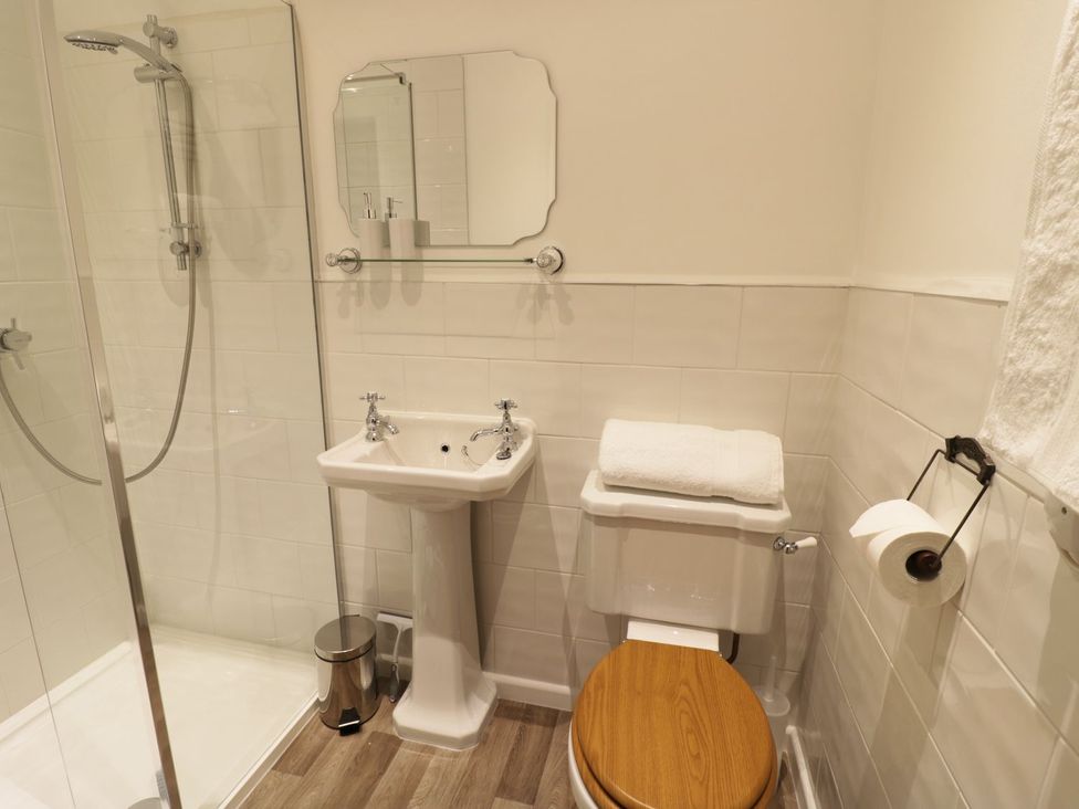 A bathroom with a shower, sink, and toilet at Glencoe Cottage Broadway