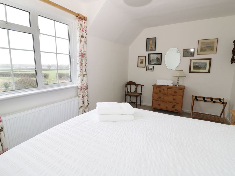 A bedroom with a bed and window at Glencoe Cottage in Broadway