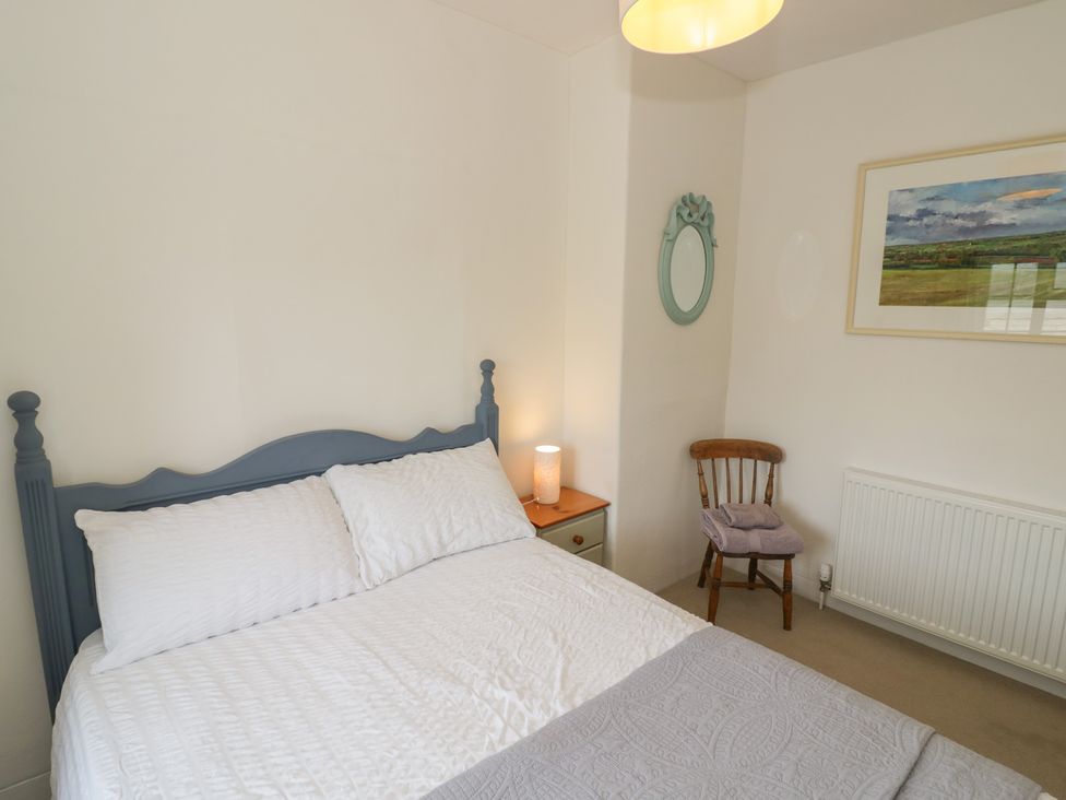 A bedroom with a bed and nightstand at Glencoe Cottage in Broadway