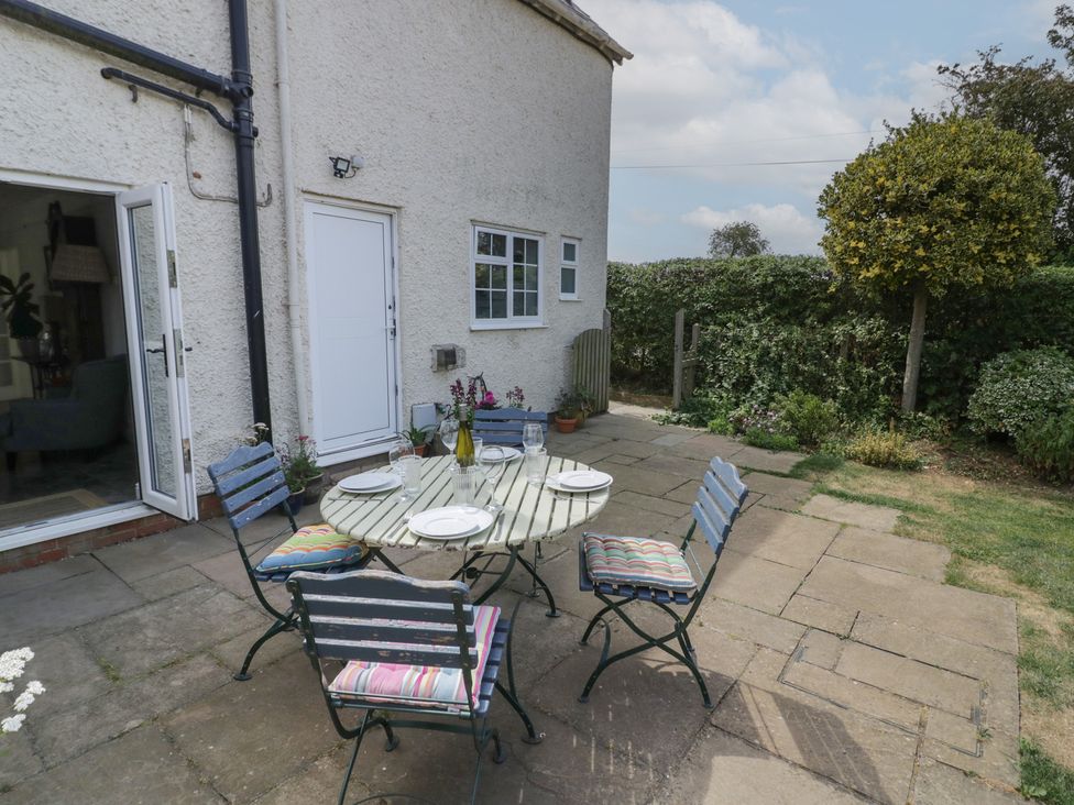 A garden with a table and chairs at Glencoe Cottage in Broadway