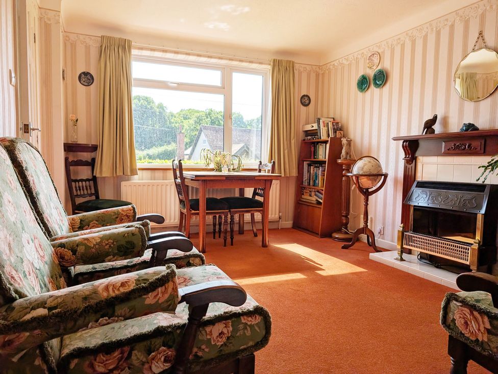 A living room with armchairs and a dining table at Roslyn in Romsey