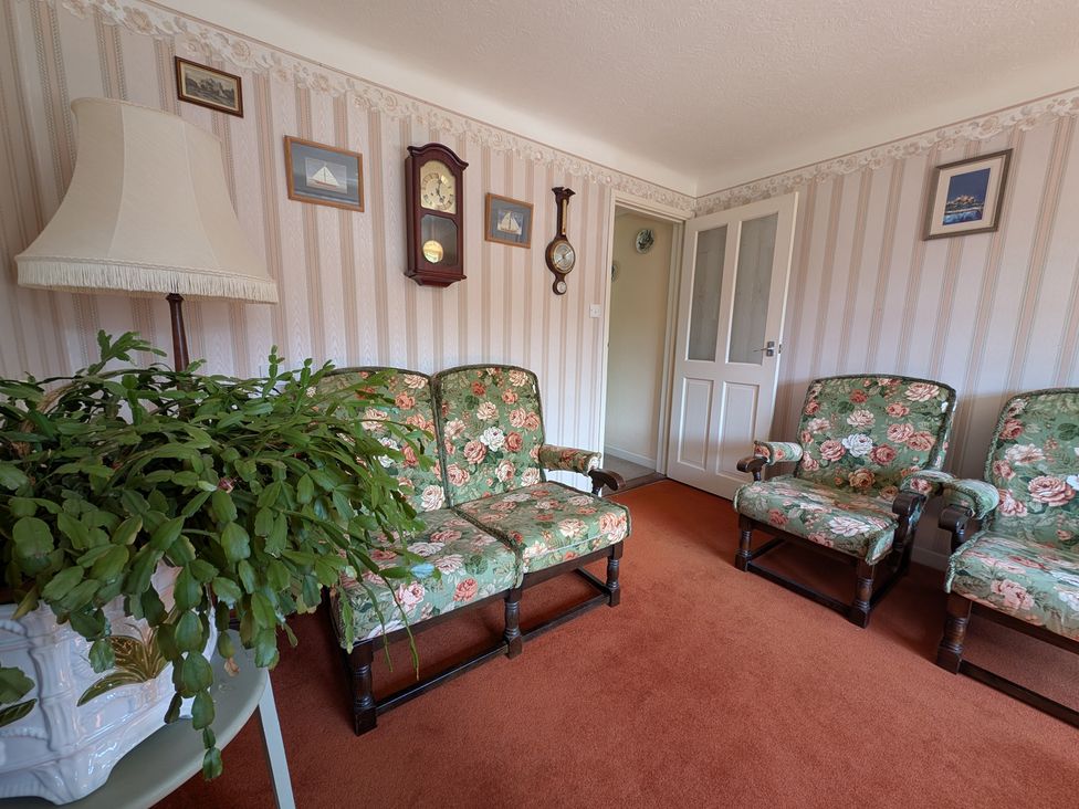A living room with floral sofas and a lamp at Roslyn in Romsey