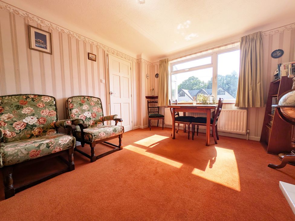 A living room with armchairs and a dining table at Roslyn in Romsey