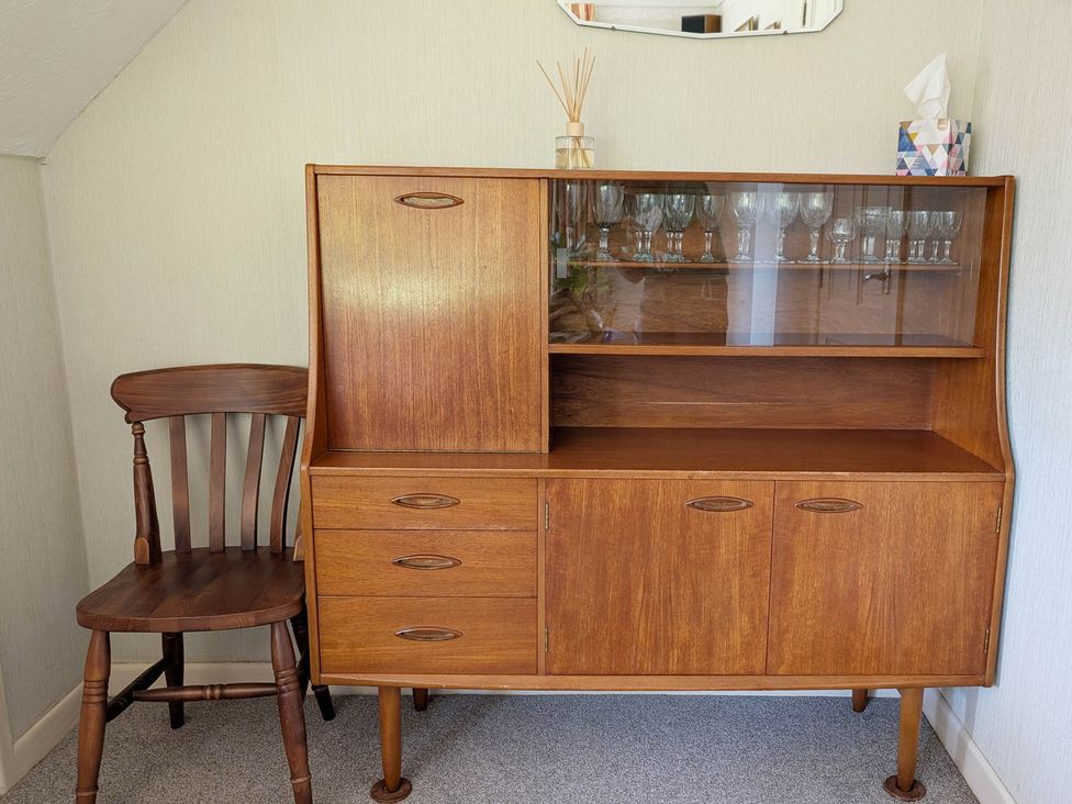 A cabinet and chair in a living room at Roslyn in Romsey