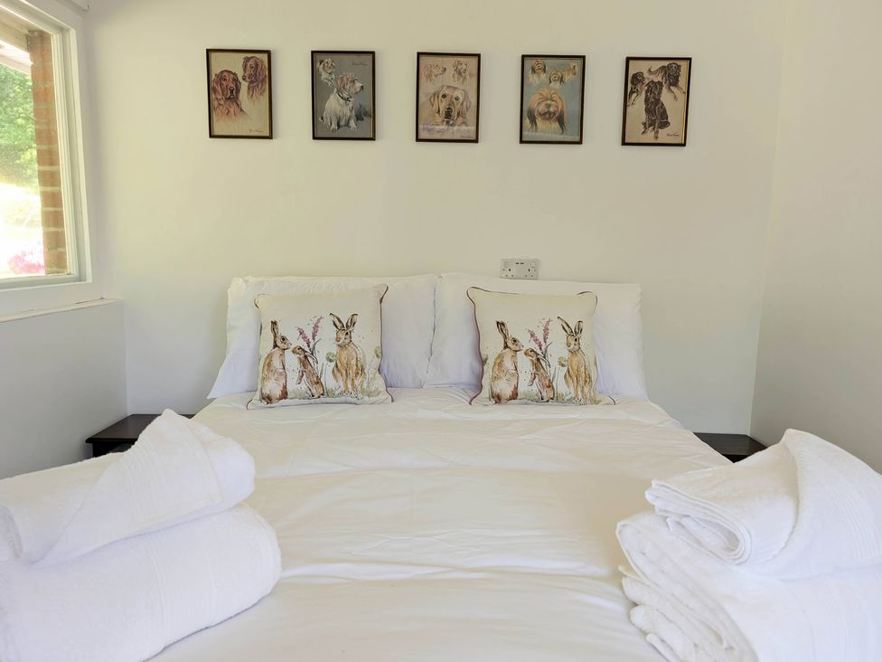 A bedroom with a bed and decorative pillows at Roslyn in Romsey