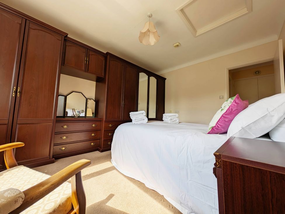 A bedroom with a bed and wardrobe at Roslyn in Romsey