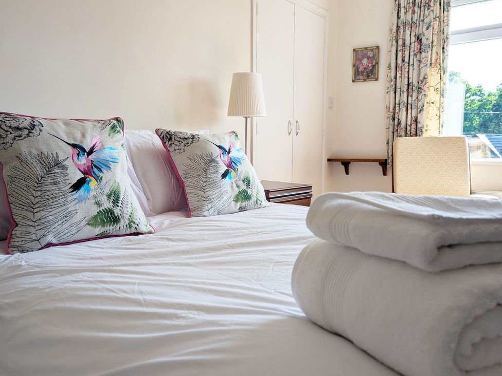A bedroom with a bed and decorative pillows at Roslyn in Romsey