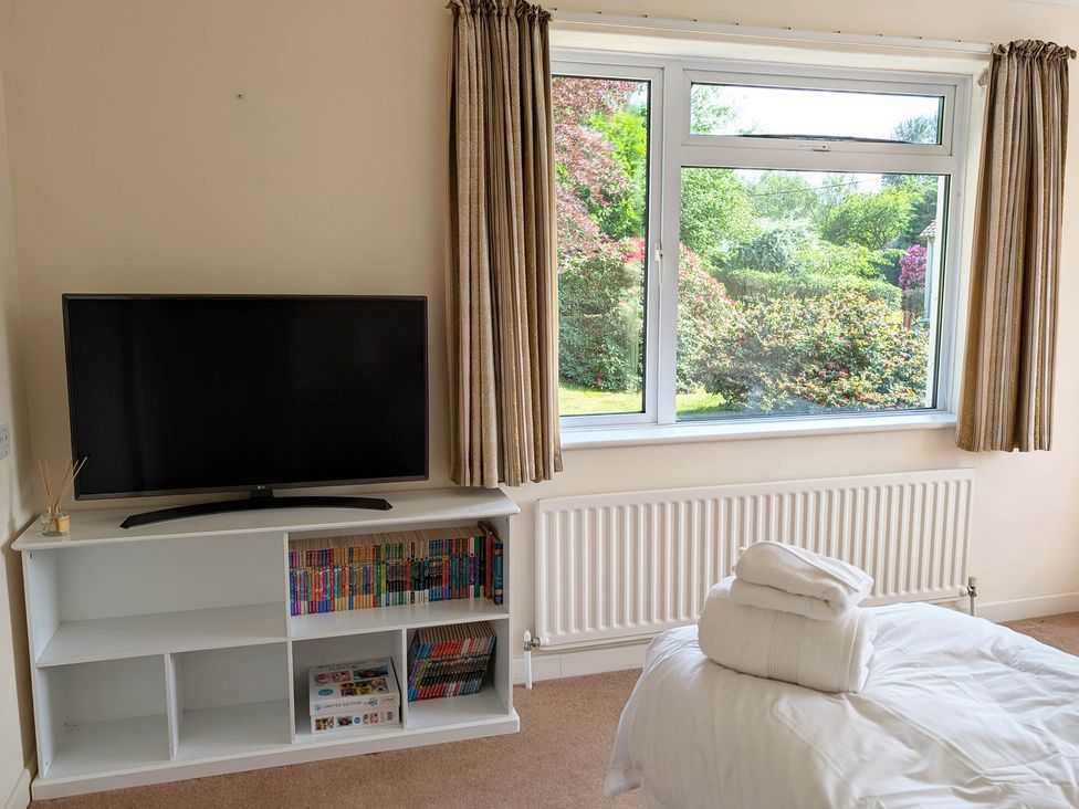 A bedroom with a television and bookshelf at Roslyn in Romsey