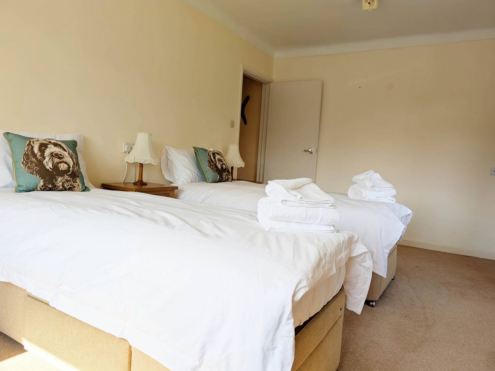 A bedroom with two beds and a bedside table at Roslyn in Romsey