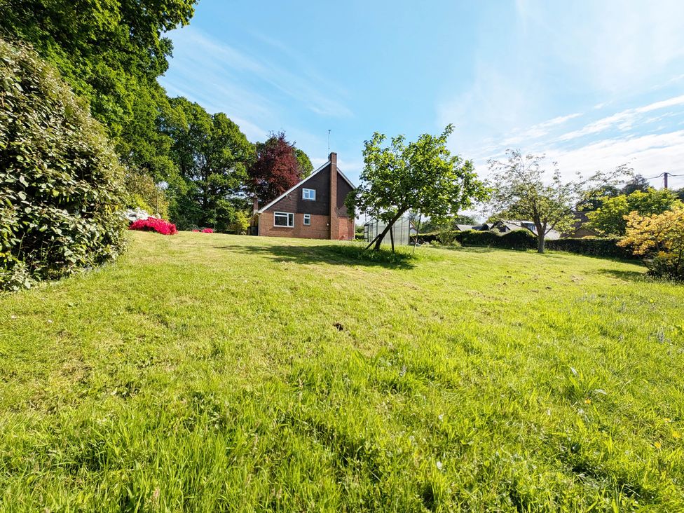 A garden with a house and trees at Roslyn in Romsey