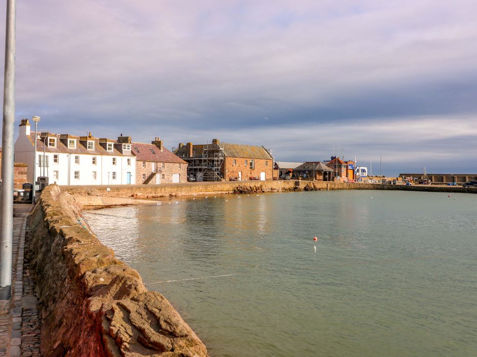 A harbor with buildings along the water at The Harbour Hoose Stonehaven