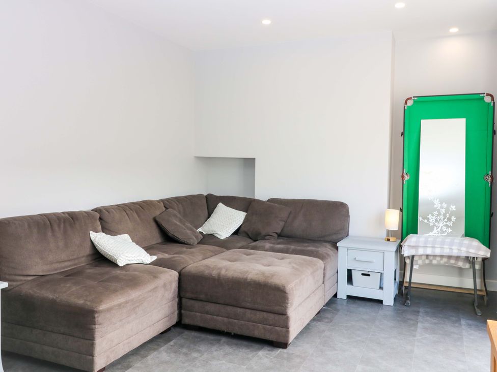 A living room with a sofa and side table at The Harbour Hoose Stonehaven