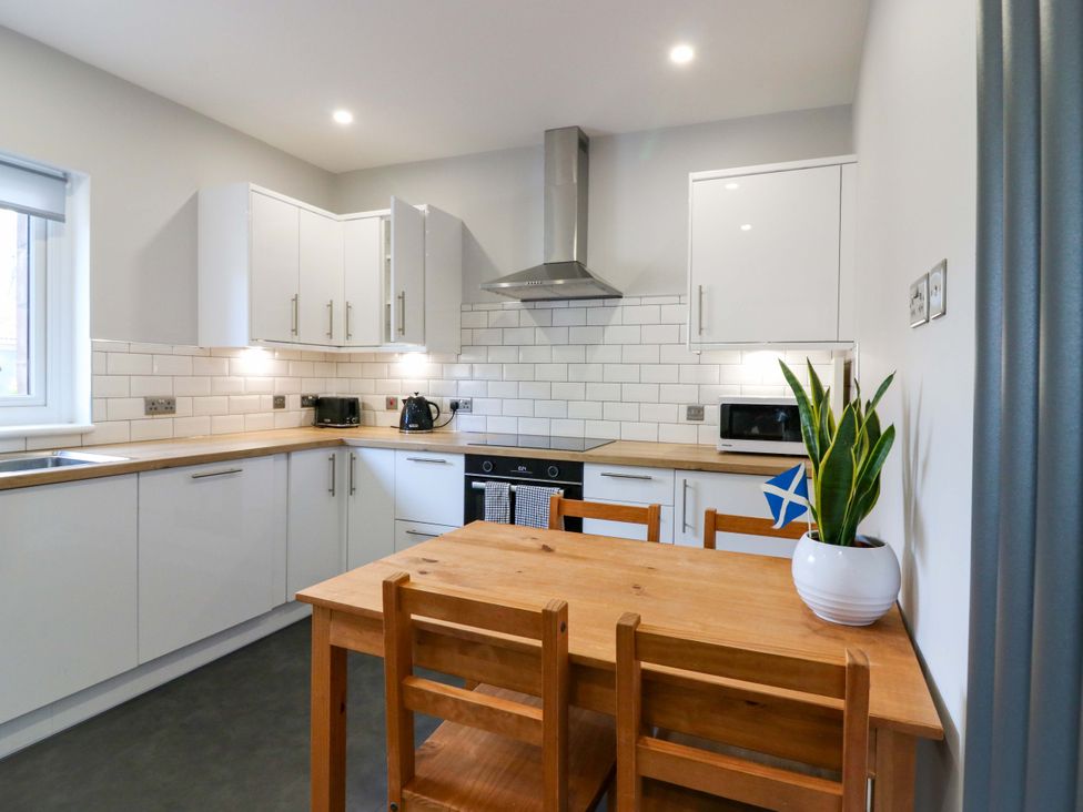 A kitchen with a table and chairs at The Harbour Hoose Stonehaven