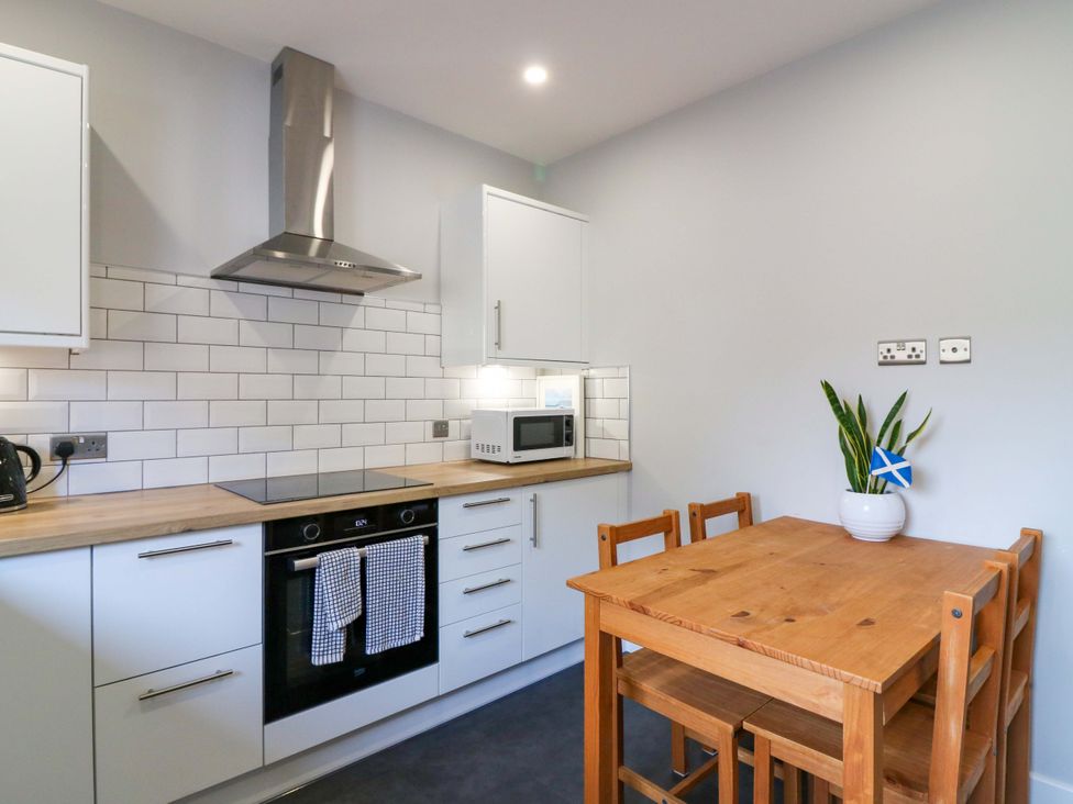A kitchen with a table and chairs at The Harbour Hoose Stonehaven