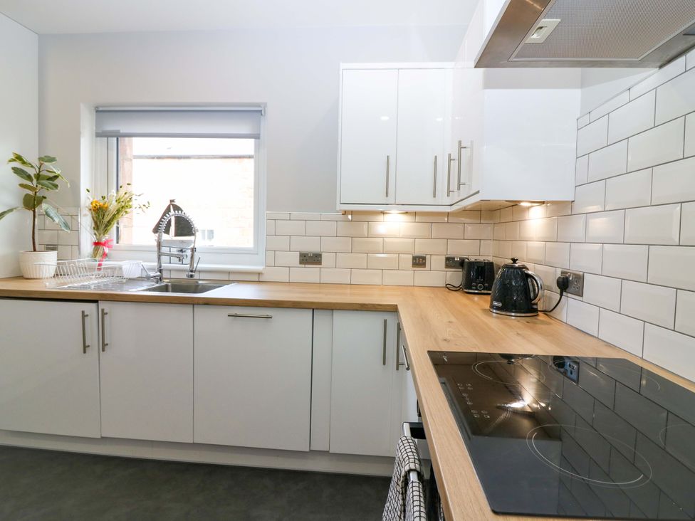 A kitchen with a sink and cabinets at The Harbour Hoose Stonehaven