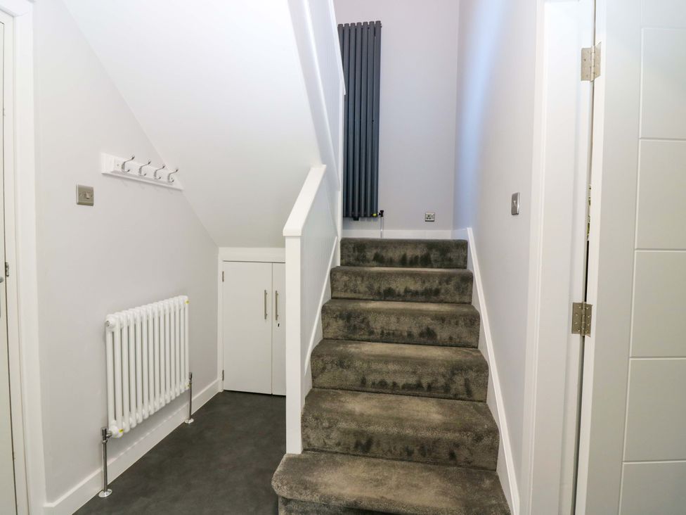 A hallway with stairs and a radiator at The Harbour Hoose Stonehaven