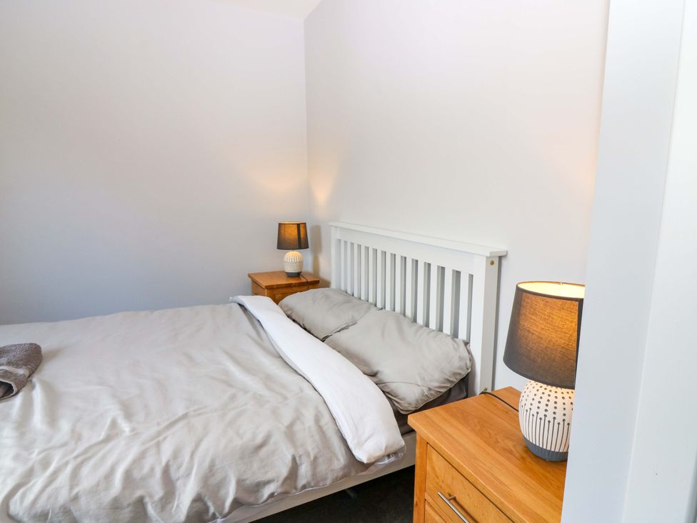 A bedroom featuring a bed and bedside tables with lamps at The Harbour Hoose Stonehaven