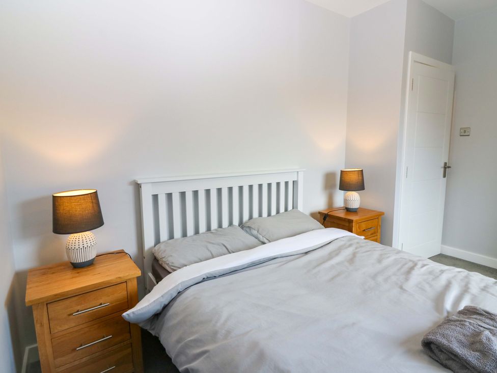 A bedroom with a bed and bedside tables at The Harbour Hoose Stonehaven