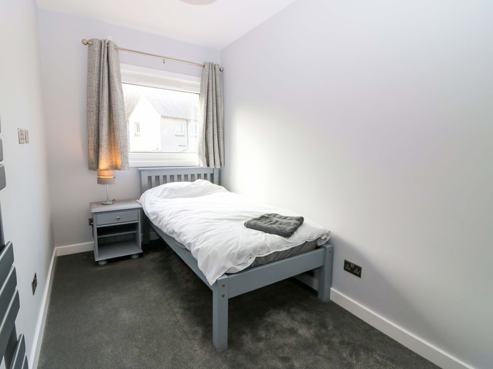 A bedroom with a bed and nightstand at The Harbour Hoose Stonehaven