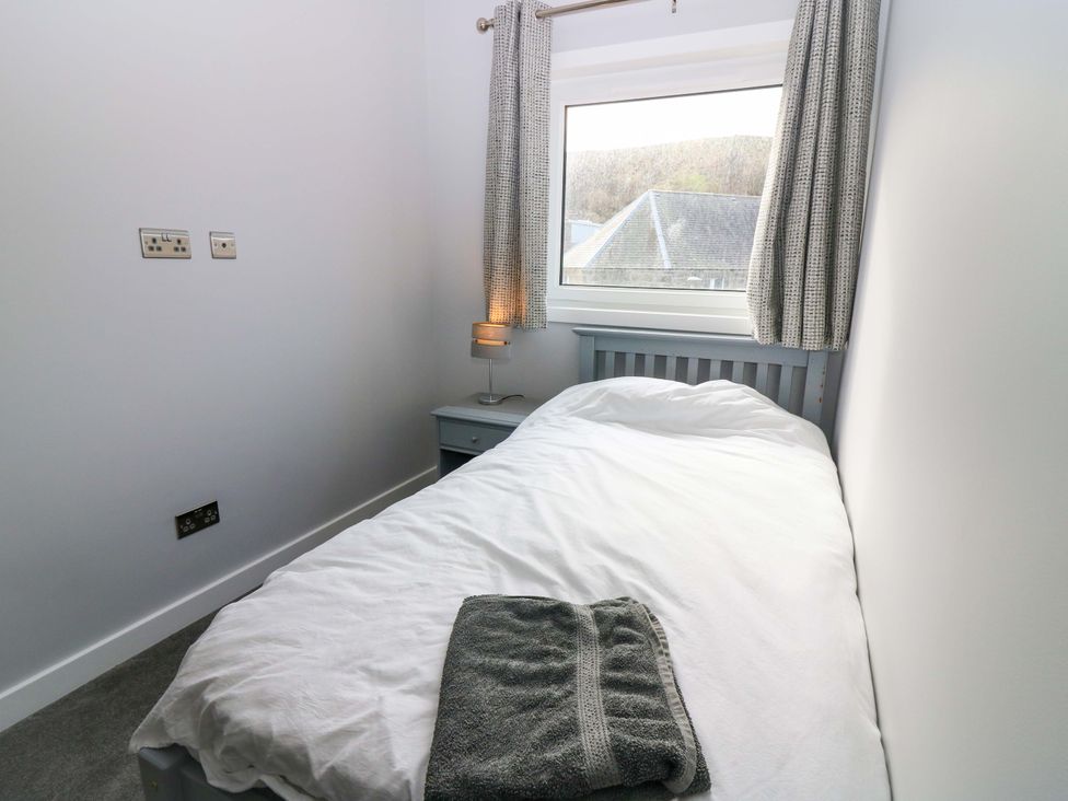 A bedroom with a bed and window at The Harbour Hoose Stonehaven