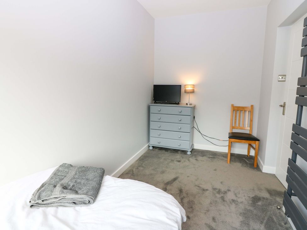 A bedroom with a bed and television at The Harbour Hoose Stonehaven