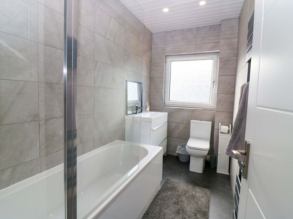 A bathroom with a bathtub, toilet, and sink at The Harbour Hoose Stonehaven