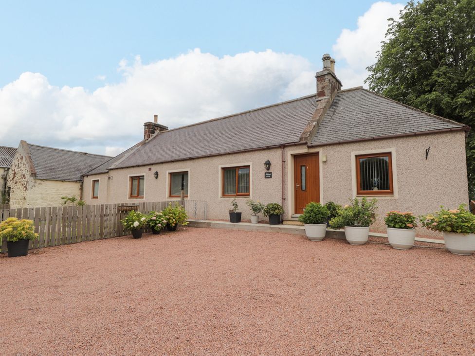 An exterior view of a house with planters and gravel at Millmoss Cottage 