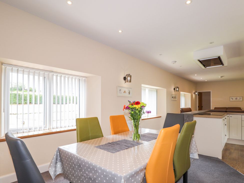 A dining room with a table and chairs at Millmoss Cottage