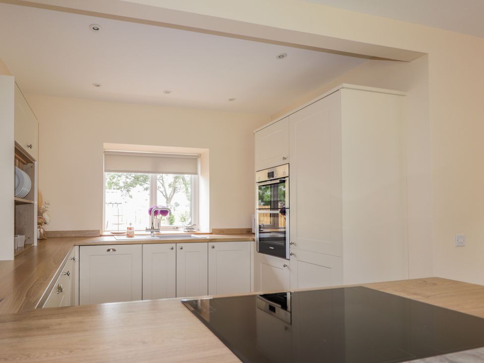 A kitchen with a sink and oven at Millmoss Cottage in 