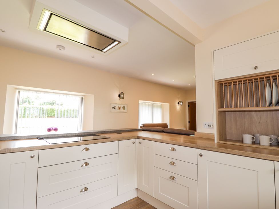 A kitchen with cabinets and a cooker at Millmoss Cottage